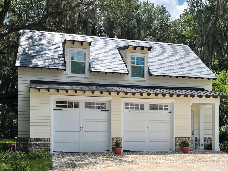 Residential garage with two white overhead doors, stylish roof, and landscaped surroundings, showcasing products from Overhead Door Company of The Desert™ for home security and convenience.
