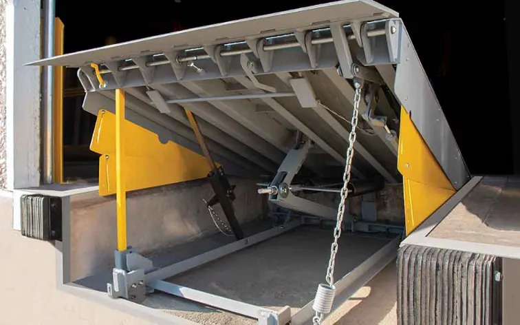Mechanical dock leveler in operational position, featuring a yellow safety edge and a sturdy design for efficient loading and unloading in commercial settings.