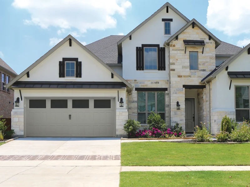 Modern residential home with a stylish garage door, showcasing landscaping and a well-maintained lawn, representing garage door solutions by Overhead Door Company of The Desert™ in Thousand Palms, CA.