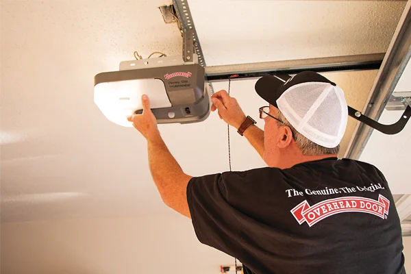 Technician installing Overhead Door operator in garage, showcasing operator accessories and quality service by Overhead Door Company of The Desert™.