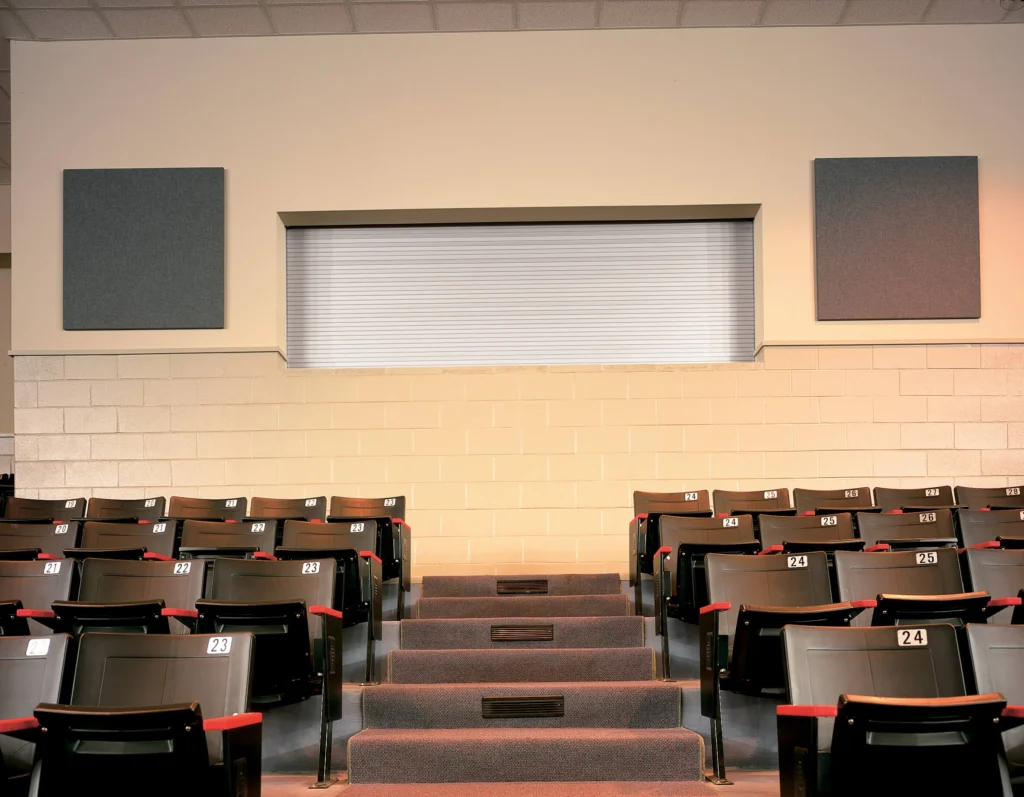 Rolling counter door in a commercial setting, featuring a sleek design, installed above auditorium seating, enhancing security and accessibility for small openings.