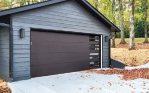 Insulated steel garage door from the Thermacore® Collection, featuring a dark bronze finish and modern panel design, set against a contemporary home exterior.