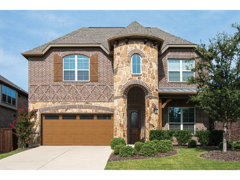 Traditional steel garage door in a modern home exterior with stone and brick facade, showcasing curb appeal and residential design.